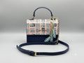 Designer handbag with a patterned flap and chain strap on a light gray background