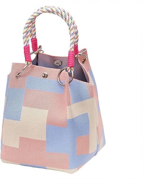 A small bucket-style handbag with a geometric patchwork pattern in pink. It features thick red rope handles threaded through silver metal O-rings at the top, set against a plain white background.